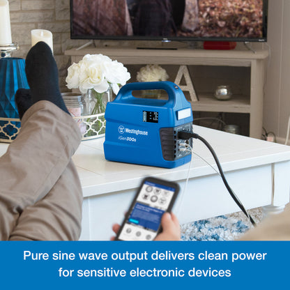 Westinghouse | iGen300s Portable Power Station sits on a table. There are several cords plugged into it. In the foreground someone is holding a phone that is being charged by the power station. A blue banner at the bottom reads, "Pure sine wave output delivers clean power for sensitive electronic devices".