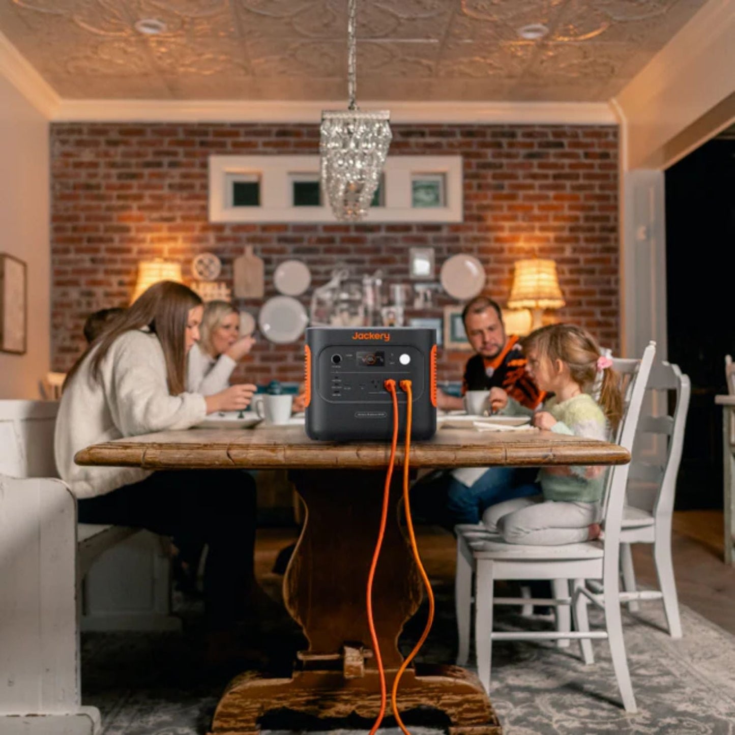 Family enjoying a meal at a long table with Jackery Explorer 2000 v2 Portable Power Station nearby