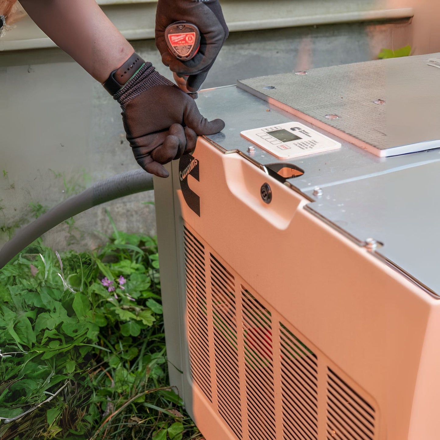 Man securing bolts on Cummins RS17A 17kW Home Standby Generator installation