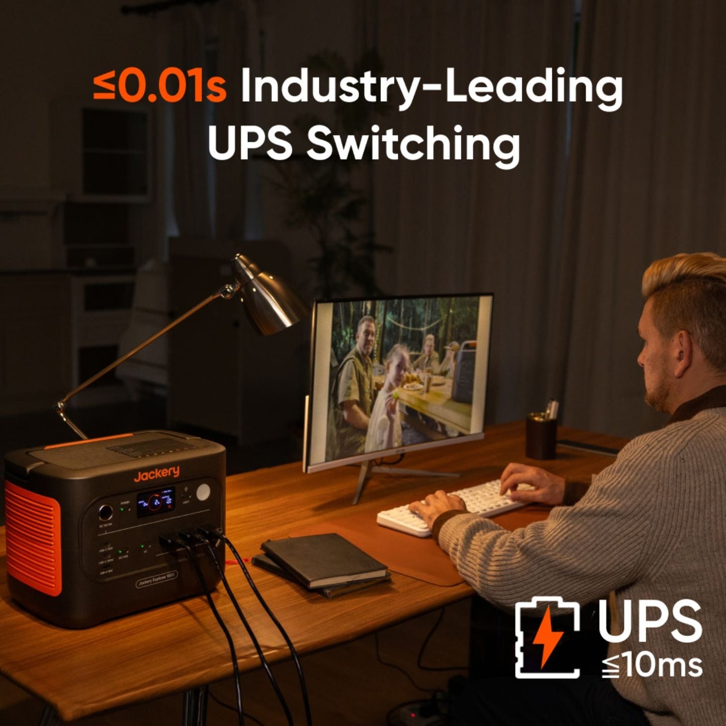 Person working at a desk with a Jackery Explorer 1500 v2 Portable Power Station emphasizing industry-leading UPS switching technology.
