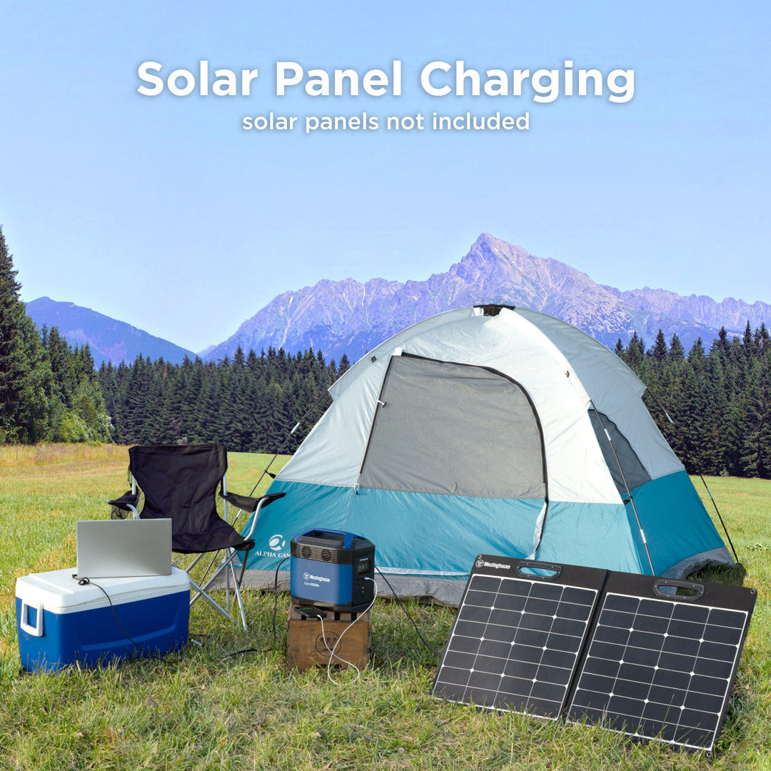 Westinghouse | iGen1000s portable power station shown being charged by solar panel and charging a laptop. The text at the top of the image says, solar panel charging, solar panels not included. There is a tent and chair in the background and the laptop is sitting on a cooler. 